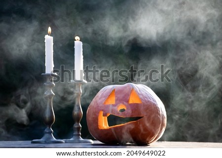 Jack O' Lanterns glowing in smoky fantasy night with candles. Halloween background