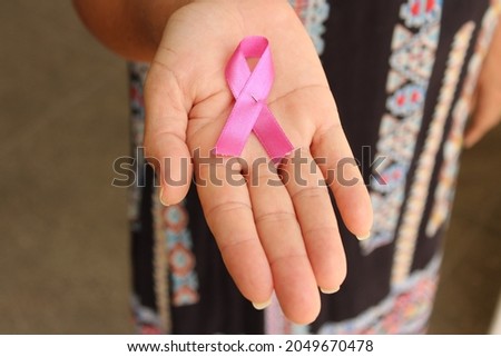 Lace emblem on female hand palm as symbol of pink october preventive campaign. Royalty-Free Stock Photo #2049670478