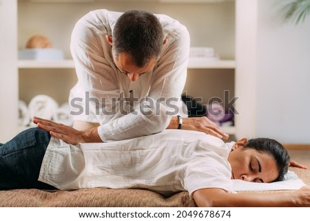 Therapist massaging woman’s back. Woman getting shiatsu back massage. Royalty-Free Stock Photo #2049678674