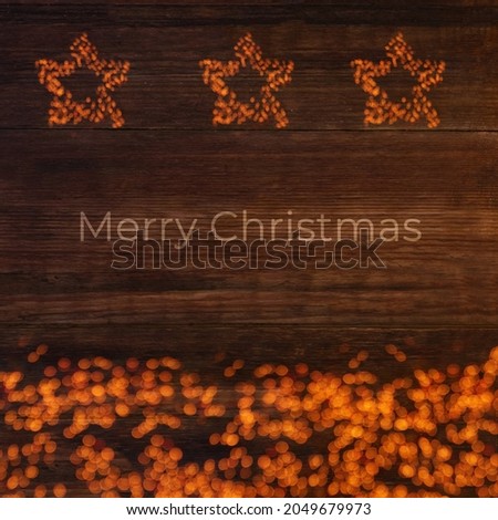 Three stars of lights on a wooden brown background with text Merry Christmas, Christmas card