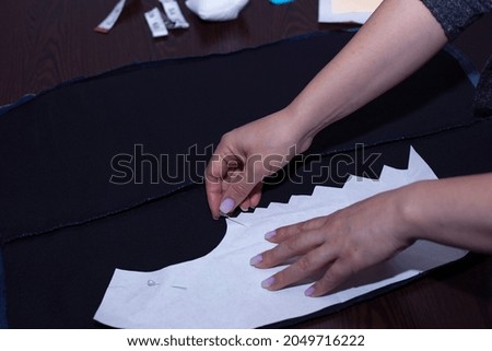  woman drawing template for sewing new dress 