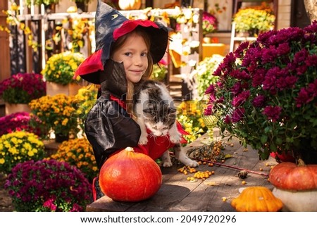 happy child girl wearing witch costumes in autumn halloween holiday