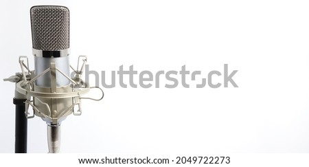 Silver and Gold Professional Condenser Microphone and Shockmount on Stand for Recording Artists, Broadcasters, Youtubers, and Vloggers. Isolated on White. Mic on Far Left with Space for Text.