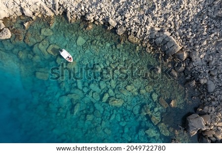Drone aerial photograph of Cape Greko peninsula. Boat in the ocean. Turquoise ocean water