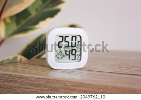 Thermometer hygrometer measuring the optimum temperature and humidity in a house, apartment or office, a photo for articles about the house’s microclimate, health, disease relief and virus treatment Royalty-Free Stock Photo #2049762110