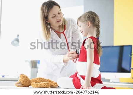 Pediatrician doctor listens to breathing and heartbeat with stethoscope of little girl. Royalty-Free Stock Photo #2049762146