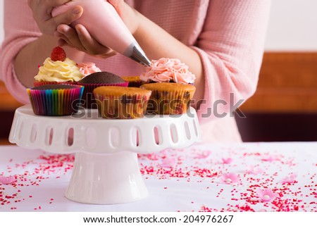 Cropped image of girl decorating cupcakes