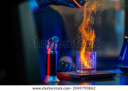 Asian man bartender making special cocktail explode alcoholic drink with cinnamon powder on bar counter serving to customer at nightclub with neon night lights. Small business food and drink concept Royalty-Free Stock Photo #2049790862