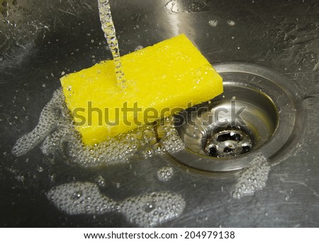 Stainless steel sink plug hole close up with water 