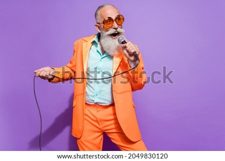 Photo of old dreamy cheerful man sing karaoke stage wear sunglass empty space isolated on purple color background Royalty-Free Stock Photo #2049830120