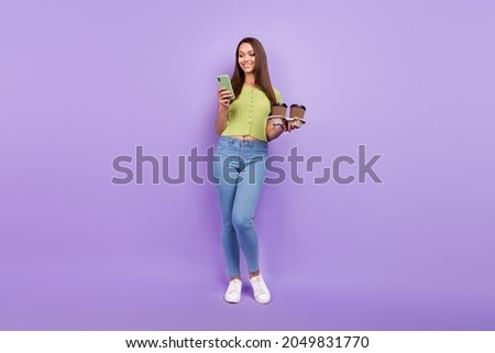 Full length body size view of pretty cheerful girl using device blogging holding latte isolated over purple violet color background