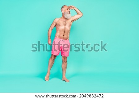 Photo of interested funny dreamy man palm forehead look empty space wear pink shorts isolated turquoise color background