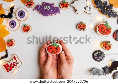 Step by step instructions on how to draw an orange pumpkin shaped gingerbread cookie using icing. Step 5, draw with black icing the outline, eyes, shadows. Halloween sweets on an isolated background