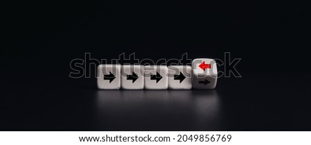 Leadership, unique, think different way concept.  White dice blocks flipping with red arrow facing the opposite direction black arrows on dark banner background, minimal style.