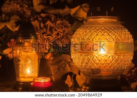 Yellow grave lanterns shining with light. Cemetery at night. Catholic Halloween tradition. All souls' day in Poland, Eastern Europe. Zaduszki. Royalty-Free Stock Photo #2049864929