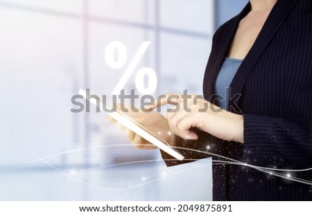 Interest rate, financial, ranking and mortgage rates concept. Hand touch white tablet with digital hologram percent sign on light blurred background. Discount commission presented by percent sign Royalty-Free Stock Photo #2049875891