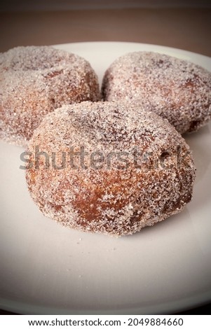 Three fried sugar covered doughnuts