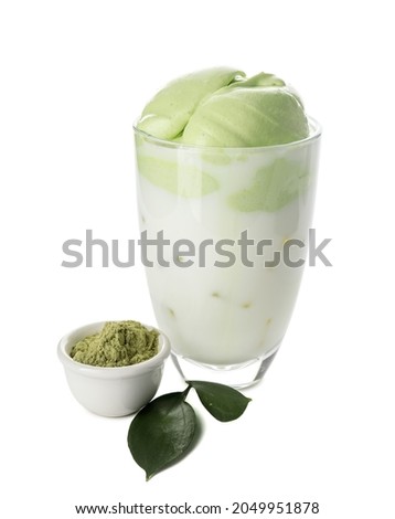 Glass of tasty dalgona matcha latte and powder on white background