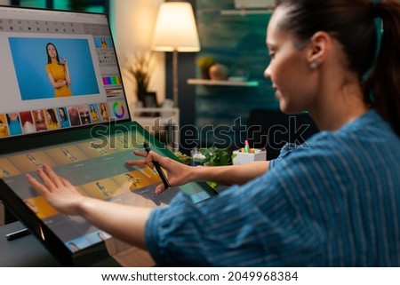 Photo editor artist doing touchpad work on retouching image using stylus and monitor screen for editing design on digital computer. Photographer woman working at production workplace