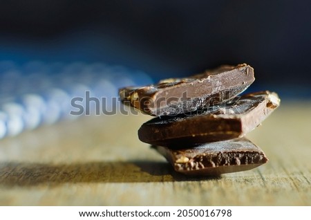 Small pieces of dark chocolate, delicious healthy dessert. Close-up, selective focus.
