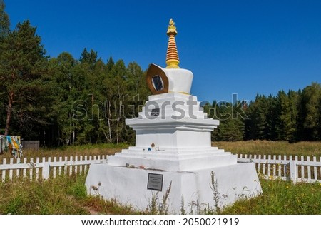 White Buddhist Stupa of an Enlightenment at summer day. Buddhist faith in Siberia. Sacred pilgrimage site for believers in Russia. Translation: “Buddhist Bodhi Stupa”