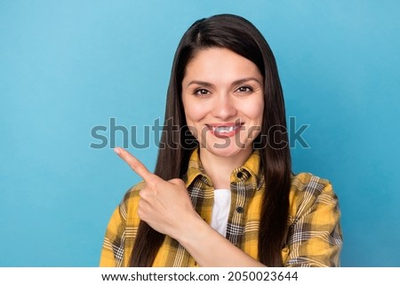 Photo of mature woman happy positive smile point finger empty space ad promo choice suggest isolated over blue color background