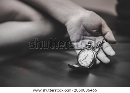 A person's aged hand is holding a vintage watch on her hand. The watch's body fell to the ground. Concept of time that has passed will never return. Exhausted and running out of time for today.