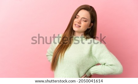 Teenager girl over isolated pink background suffering from backache for having made an effort