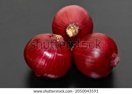 photos of red onions on a black background.