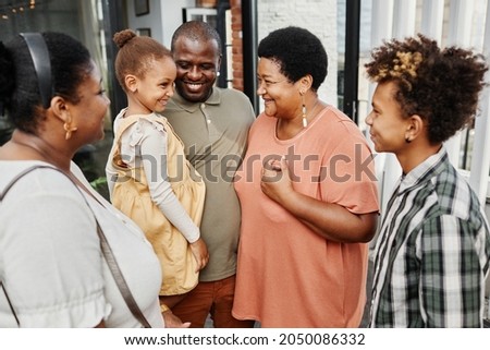 Portrait of happy multi-generational family chatting during gathering outdoors at terrace Royalty-Free Stock Photo #2050086332