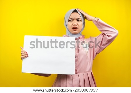 Pretty young muslim woman shocked, surprised, wow, hand holding blank empty banner, placard, white board, blank sign board, white advertisement board, presenting something in copy space, promotion