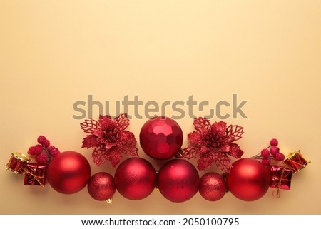 Christmas composition. Christmas red and golden decorations on beige background.