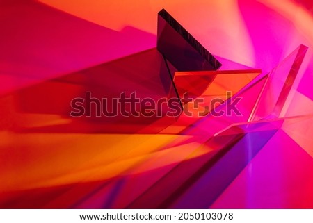Multicolored glass on colorful gradient background. The light travels through different acrylic sheets. Stylish abstract background Royalty-Free Stock Photo #2050103078