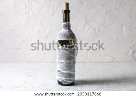 Bottle of cocktail decorated as mummy. Drink for a halloween party for kids.