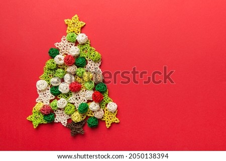 Christmas tree made from colored handmade ball decoration on colored background, view from above. New Year minimal concept with copy space.