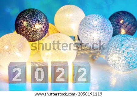 Bright new year garland and text 2022 laid out with cubes. Happy New Year 2022 celebration. Happy New Year 2022. Creative lettering Happy New Year 2022