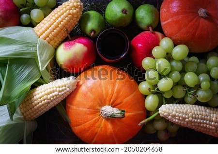 Kwanzaa Afro American holiday. Treats on table in honor of kwanzaa holiday. Principles of African Heritage. Pumpkin, corn, grapes, pears, apples and wooden bowl. Top view.