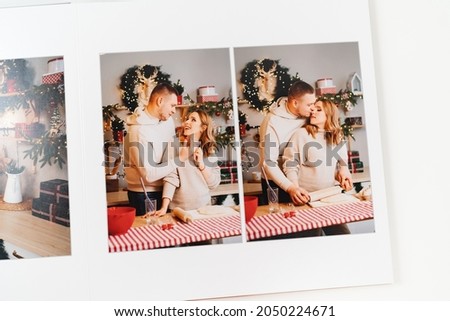 page of photobook from photo shoot of couple during pregnancy in new year's kitchen. storage of photos in photo album. work of designer, photographer and printer. memory of important moments of life