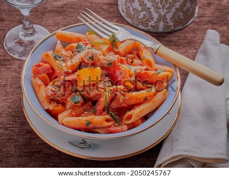 Chicken and pasta with vegetables and mixed herbs.