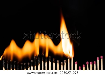 Row of matches making graph on black background, isolated. Bright fast fire spreads on matchsticks. Royalty-Free Stock Photo #2050271093