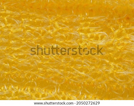 close up, background, texture, large horizontal banner. heterogeneous surface structure bright saturated yellow sponge for washing dishes, kitchen, bath. full depth of field. high resolution photo