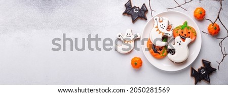 Halloween gingerbread cookies on white plate on stone background. Bright homemade cookies for Halloween party. Copy space - Image