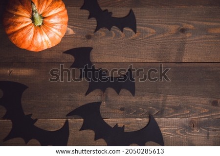 Halloween, three pumpkins on the table, bat, place for text. High quality photo