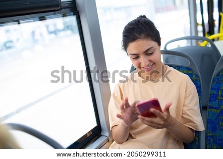 Indian Woman ride in public transport bus or tram with mobile phone Royalty-Free Stock Photo #2050299311