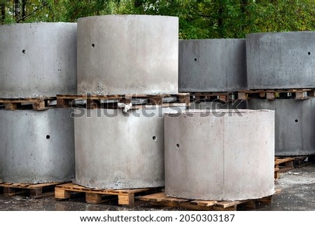 Reinforced concrete rings of a well or sewer in outdoors. Industrial production structures at store's trade exhibition. Reinforced concrete products on construction site. 