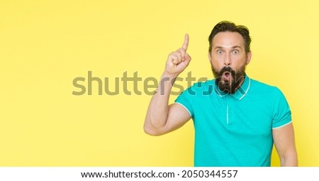 Surprised man with open mouth keep finger pointing up. Beraded man surprised with epiphany and sudden inspiration. Every inspiration is a fresh beginning. Unlock your potential
