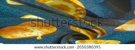Silk fabric, blue with a print of yellow autumn leaves. Texture, background pattern