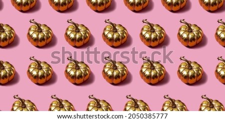 Seamless pattern with golden pumpkins on a pink background. Autumn concept in a modern style. High quality photo