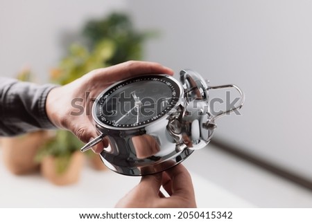Time management concept. Male hand adjusting or changing the time on clock.  Royalty-Free Stock Photo #2050415342