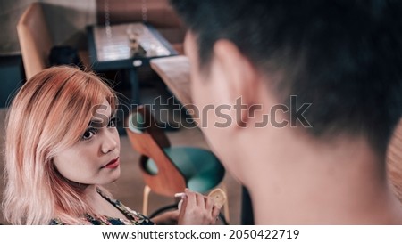 A young woman looks at an strange man approaching her. Attempted pickup line or forgotten acquaintance. Royalty-Free Stock Photo #2050422719